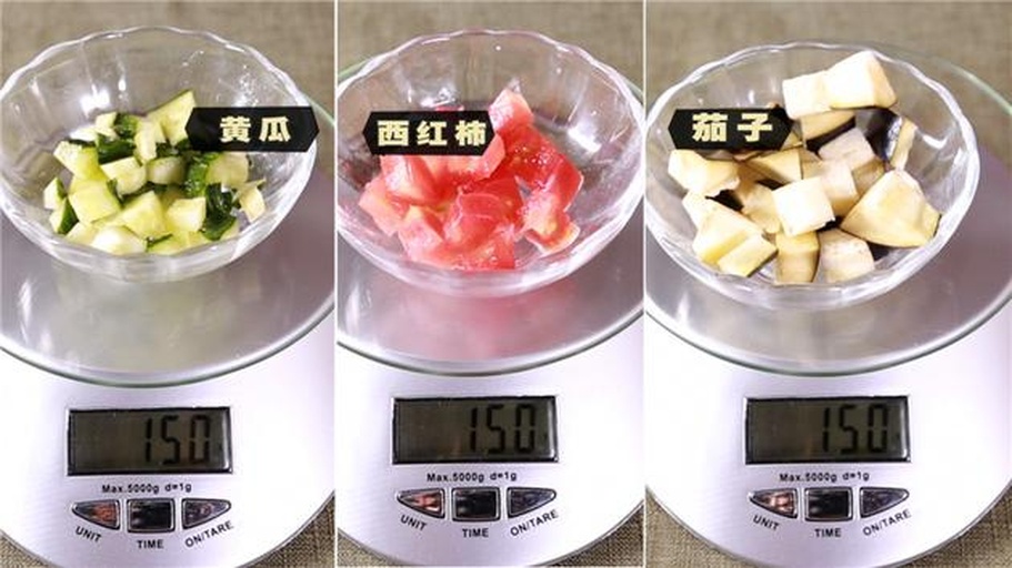 厨房台面上摆放切好的茄子片与烹饪工具，旁边放着电子秤显示重量为450克