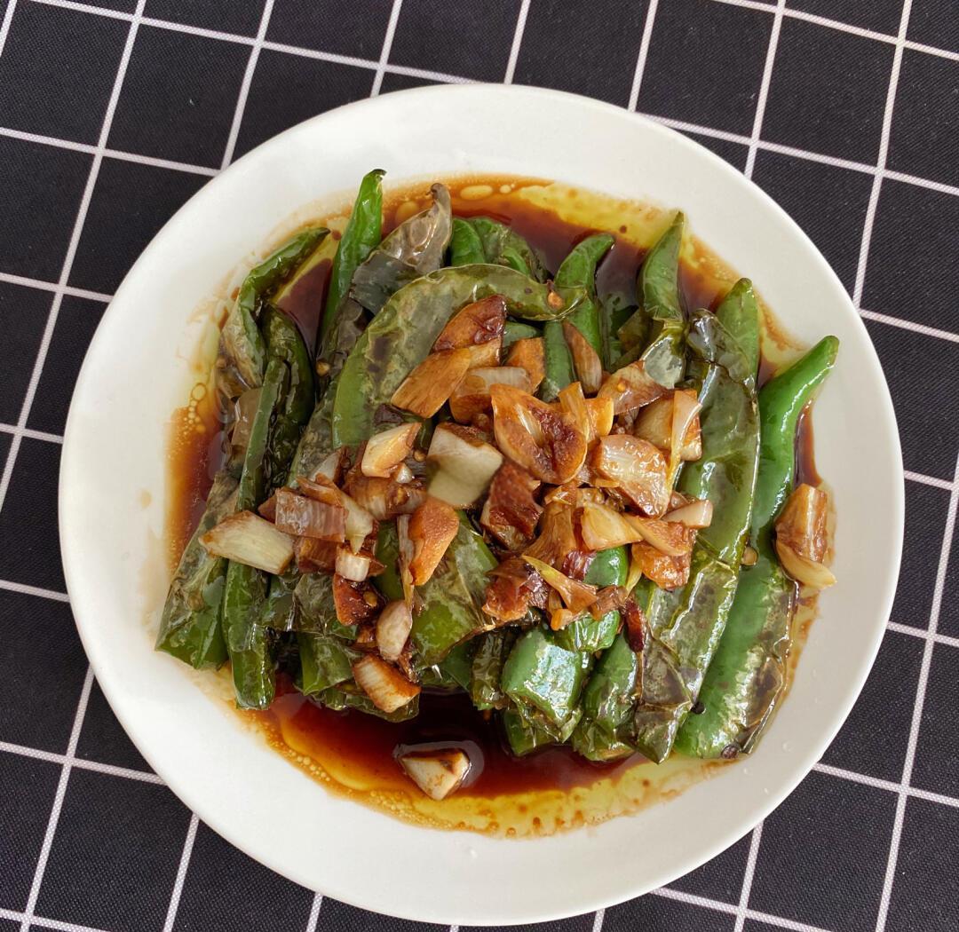 白豆角蒜蓉清炒过程图：高温铁锅中豆角段在金黄蒜末与红椒段间翻飞，油光亮泽，豆角已褪去深绿呈现鲜亮浅黄绿色，锅底无积水