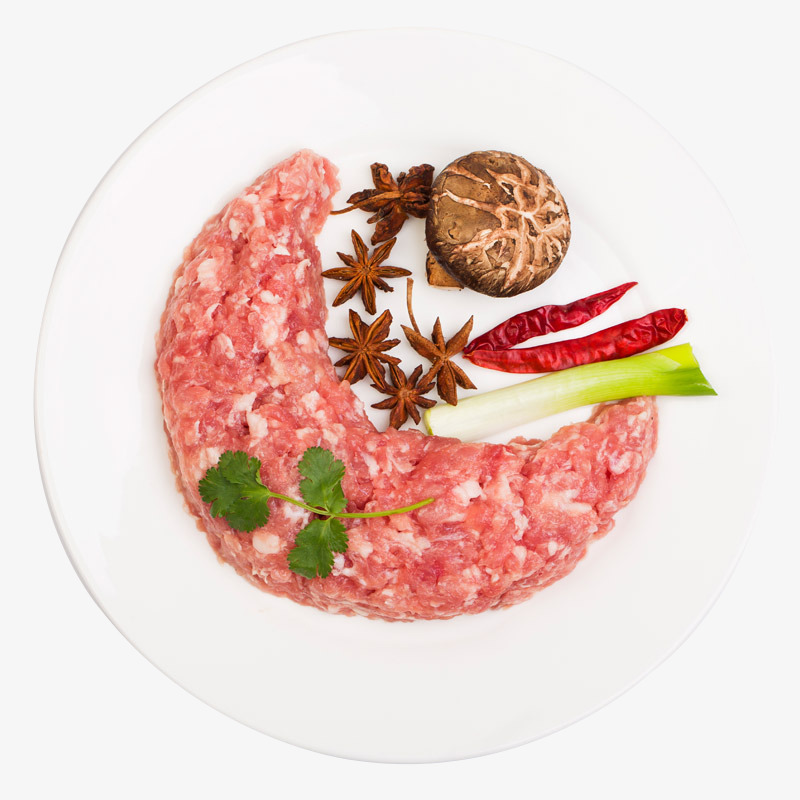 厨房操作台上整齐摆放着切好的猪里脊肉片、洗净的黄瓜条、红色泡椒、蒜末、姜末和葱段,背景为中式炒锅与调味瓶,展现即将开始烹饪的准备状态 准备食材