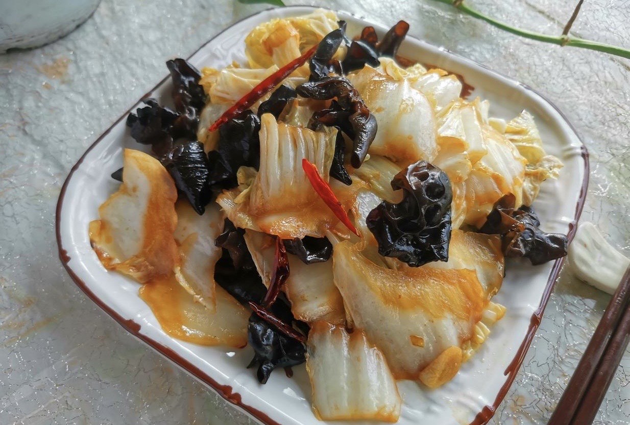 俯拍高清图:纯白瓷圆盘中盛放刚出锅的白菜炒木耳,黄心白菜嫩黄芯段鲜亮饱满、深绿帮条笔直脆挺、黑木耳朵朵舒展油亮,点缀几粒金黄蒜片与红小米辣圈,盘底无任何汤汁,整体色泽明快、油润不腻,蒸汽微升 白菜炒木耳出锅装盘特写
