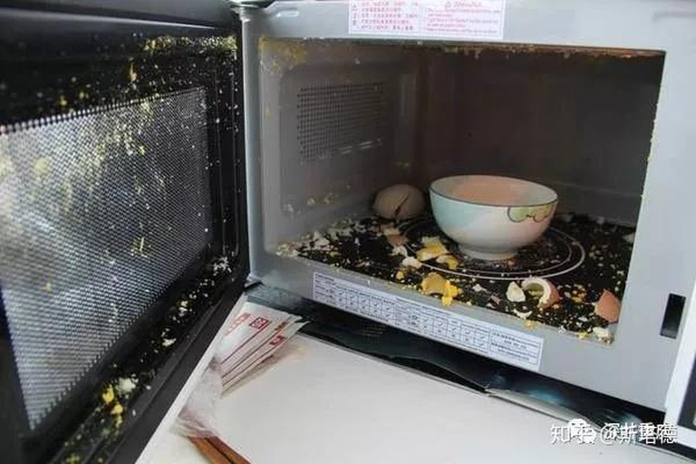 一台打开的微波炉内部,正在加热一只打在白色瓷盘上的鸡蛋,蛋清部分已半凝固,蛋黄完整但表面有细微穿刺痕迹,周围有烘焙纸边缘可见 图片描述