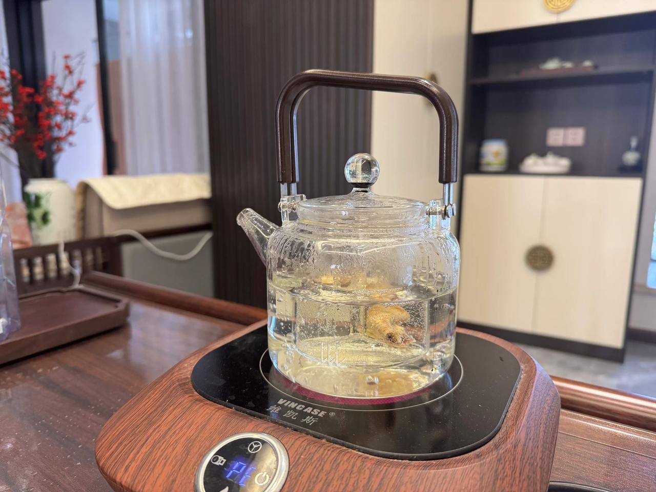 小金桔与普洱茶在玻璃壶中小火熬煮场景