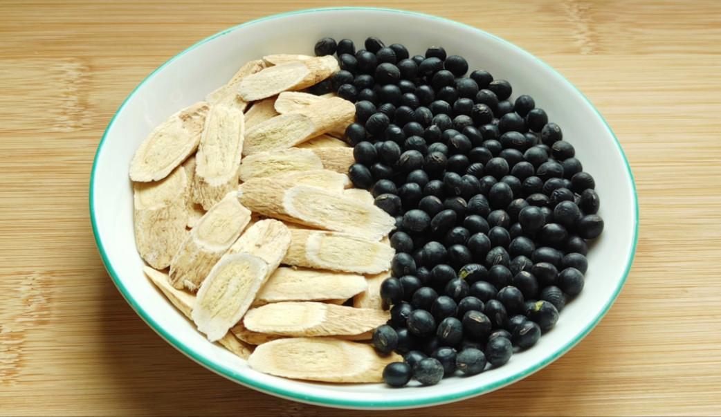 女性在厨房熬煮黑豆北芪水场景