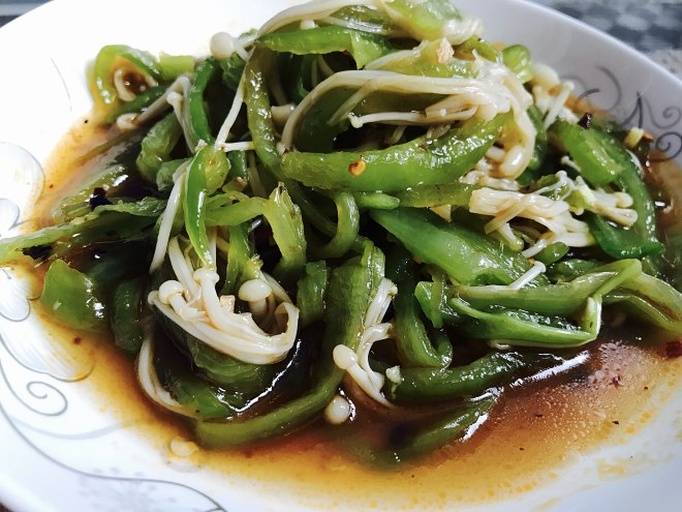 高清俯拍:左侧为刚掰去老根的整簇金针菇,菌盖完整;右侧为手挤控水后的金针菇堆,表面干燥无水珠;中间砧板上是去籽去筋后切成均匀菱形片的青尖椒,色泽鲜亮、边缘锐利 金针菇与尖椒精细处理过程特写