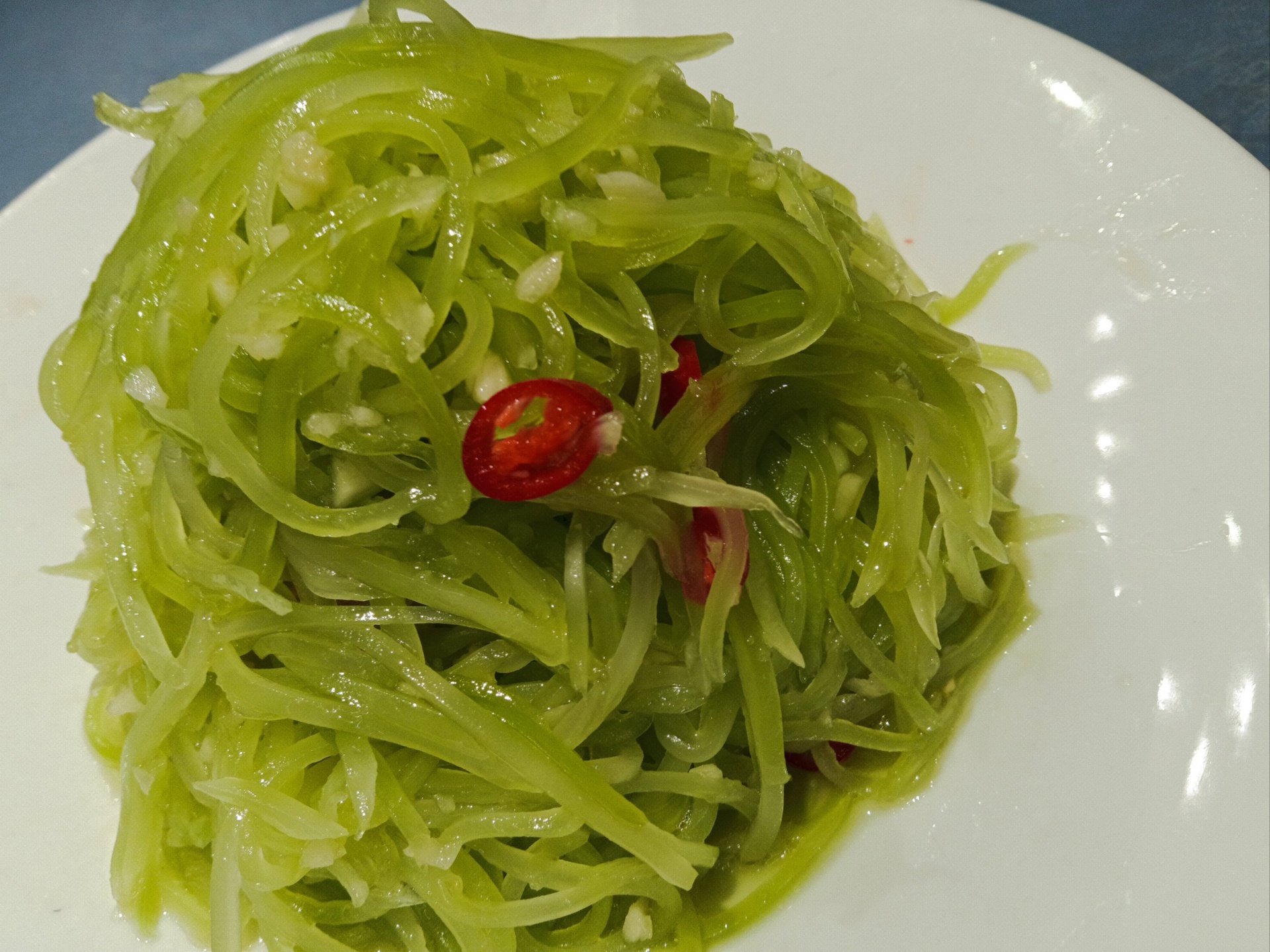 糖醋莴苣成品特写:莴苣片保持完整菱形轮廓,色泽青翠欲滴,表面覆薄层透亮琥珀色酱汁,白芝麻粒粒分明,无汁水积聚,盘底洁净,整体呈现清爽高颜值的家常宴客级摆盘效果 成品糖醋莴苣盛于青瓷圆盘,莴苣片翠绿透亮、排列整齐,表面均匀裹着琥珀色糖醋汁,撒有饱满白芝麻,盘边点缀两片新鲜薄荷叶