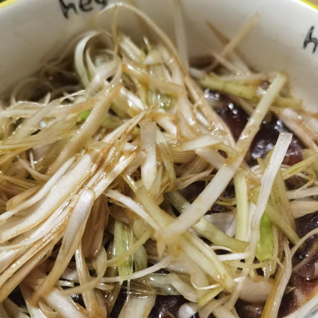小葱作为调味食材在热菜中的经典应用,强调最后淋油激发香气的烹饪时机,呼应硫代亚磺酸盐热敏性特征 中式家常烹饪中小葱的应用实景:青花瓷碗中盛放刚出锅的清蒸鲈鱼,鱼身铺满翠绿小葱丝,热油淋下瞬间葱香升腾,葱丝微卷显嫩,凸显‘出锅即撒’的活性保留关键工艺
