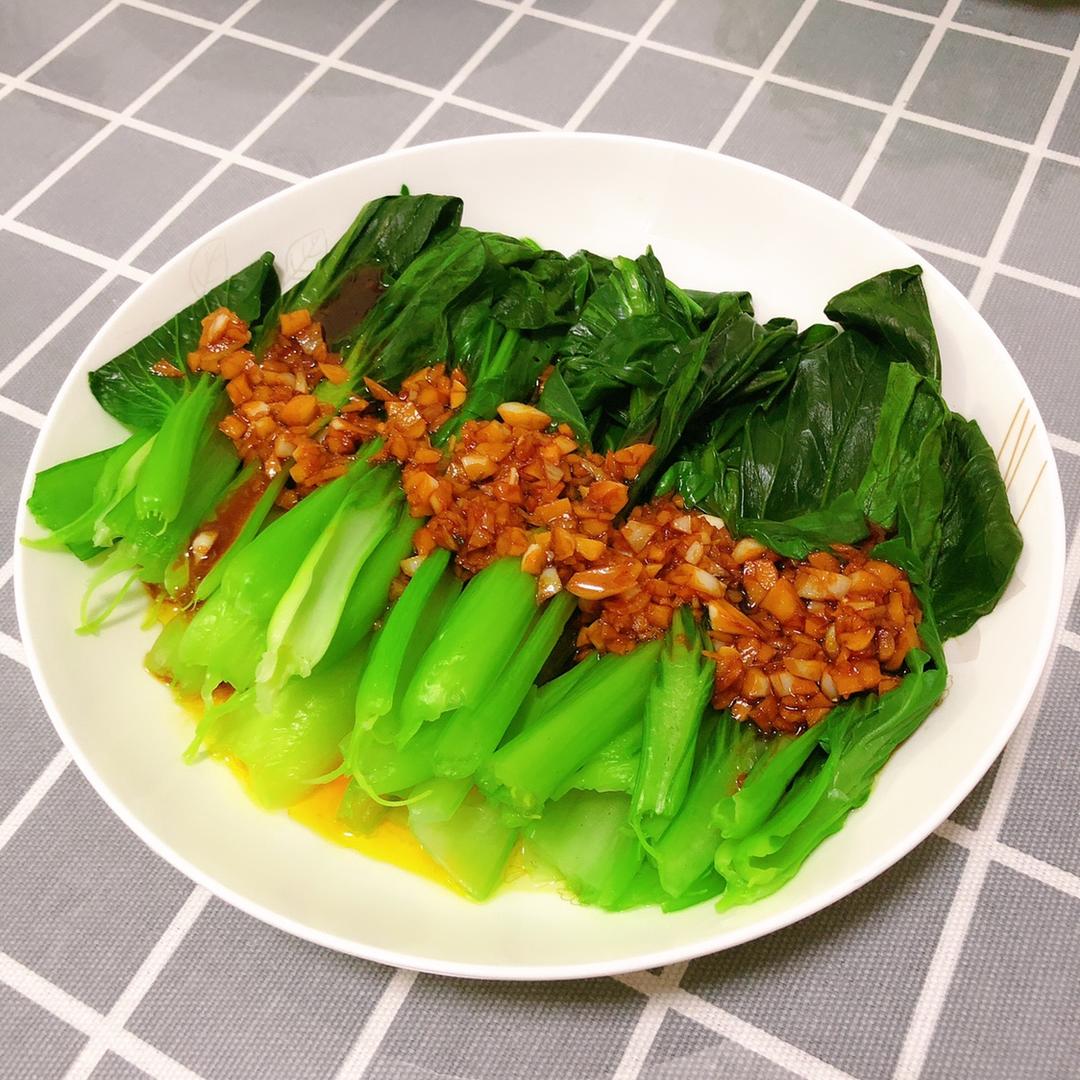 图示:蒜蓉油菜成品标准——油菜根茎分明、蒜粒金黄不焦黑、盘底洁净无水痕、红椒丝点缀增食欲 蒜蓉油菜成品特写:翠绿油菜整齐码放盘中,表面覆着金黄蒜蓉与细红椒丝,油光润泽不反光,叶脉清晰可见