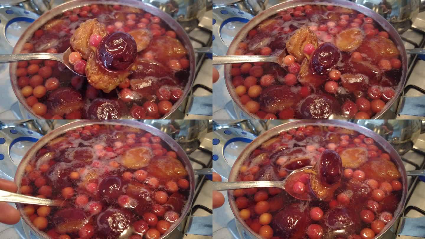 一口黑色砂锅中正在熬煮的李子酱,呈现深红琥珀色,表面微微冒泡,木勺插入可见浓稠拉丝状态,背景为厨房操作台,旁边摆放柠檬片和玻璃罐 慢火熬煮中的李子酱特写