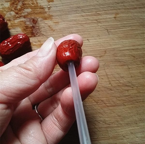 人体消化系统剖面图,标注食道、胃、小肠、大肠路径,红色箭头指示一枚椭圆形红枣核从口腔经胃至结肠的移动过程,配简要文字说明各阶段时间 人体消化道中异物移动示意图