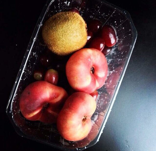 一张餐桌上的健康蟠桃食谱展示:左侧是一碗由切块蟠桃、蓝莓、坚果和酸奶组成的水果碗;右侧是一份绿色蔬菜沙拉配蟠桃片,旁边放有一杯鲜榨蟠桃汁,背景为木质餐桌和自然光线 蟠桃健康食谱图