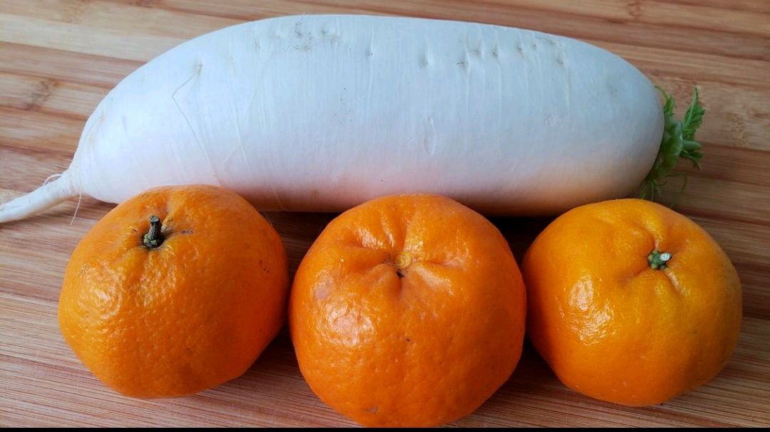 一张木质餐桌上摆放三款以红皮萝卜汁为主角的食品:一杯粉红色透明果汁、一碗粉紫色思慕雪、一小盘晶莹剔透的粉色果冻,背景有柠檬片和新鲜红皮萝卜切片装饰 红皮萝卜汁搭配多种饮品与料理