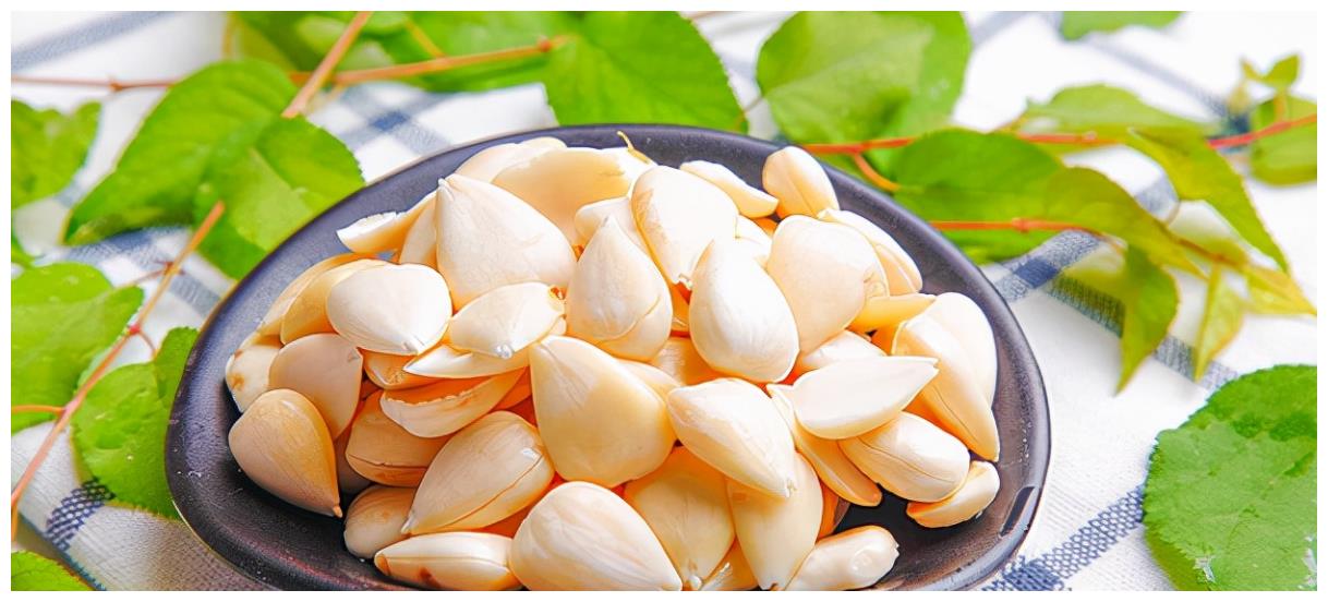 一把刚清洗过的新鲜蒜苗平铺在木质砧板上,水珠晶莹,叶片翠绿,根部洁白,旁边放有一把不锈钢厨刀,背景虚化,展现家庭厨房温馨氛围 厨房中新鲜蒜苗特写