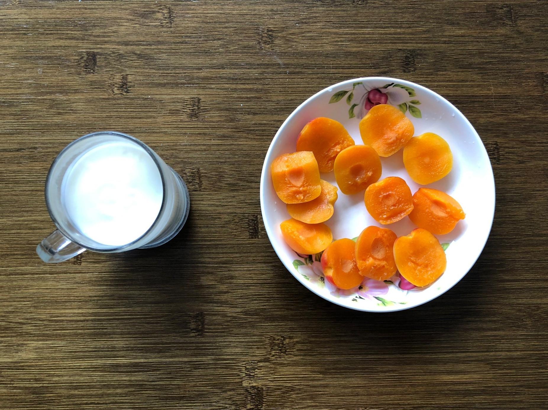 一张木质餐桌上摆放着切好的红星苹果片,旁边有一杯牛奶和全麦面包,营造健康早餐氛围,光线柔和温馨 家庭餐桌上的红星苹果