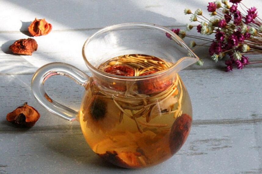 一位中年女性在厨房用玻璃壶冲泡干红枣片与枸杞,阳光透过窗户洒在操作台上,旁边摆放着密封罐装的干红枣片,体现健康生活方式 家庭食用场景