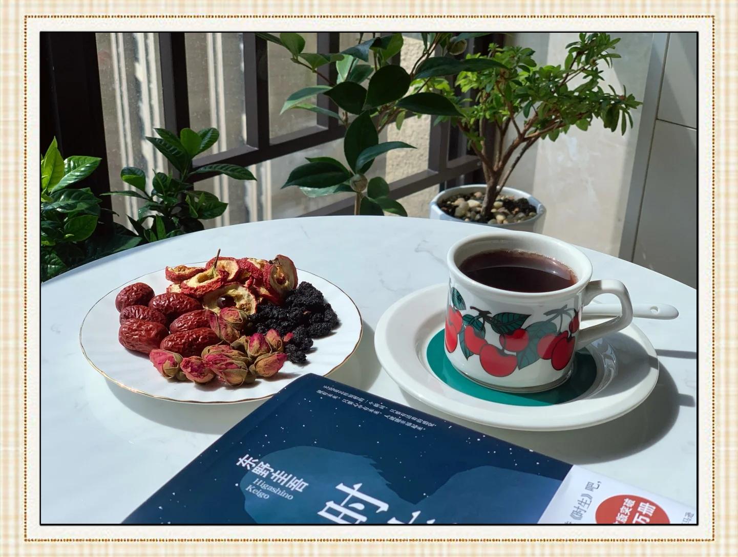 一位年轻女性身穿居家服,坐在黄昏时分的阳台上,手中拿着半个剥好的柿子正在食用,桌上放着一杯温水和一本打开的书,整体氛围宁静温馨,体现健康生活方式 女性在傍晚阳台吃柿子场景