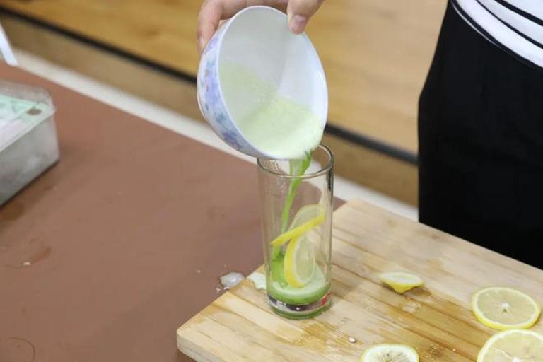 柠檬绿茶制作场景图:展示冲泡所需的器具与原材料,包括绿茶叶、新鲜柠檬、玻璃壶、榨汁器,体现家庭自制过程 厨房操作台上摆放着玻璃壶、柠檬切片、绿茶叶、榨汁器和量勺,展示制作柠檬绿茶的全过程工具与原料