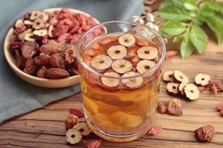 对比图：左侧为红桃K口服液瓶身标签特写，右侧为新鲜黑木耳、菠菜、猪肝等天然补血食材组成的健康餐盘