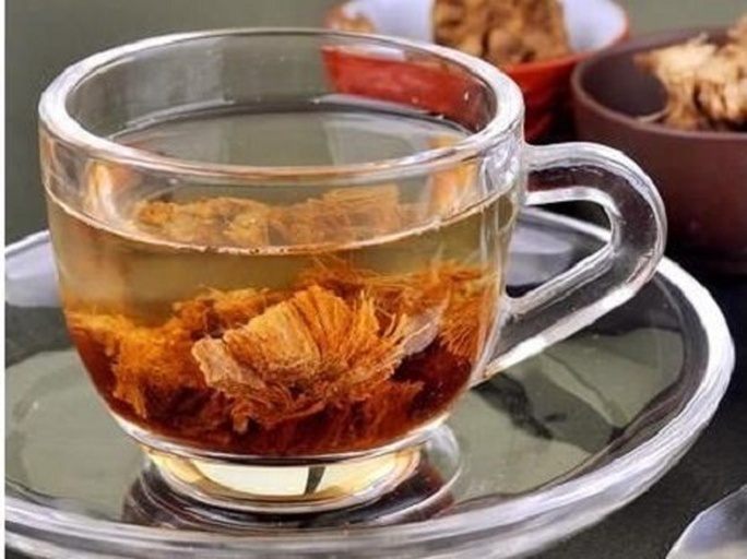 玻璃量杯盛装琥珀色汤液,表面浮有细微山药黏液膜,沉底可见陈皮纤维碎屑与雪梨果肉微粒,无浑浊沉淀,杯壁附着均匀油性光泽(源自陈皮柠檬烯) 山药陈皮雪梨煮水成品汤液特写