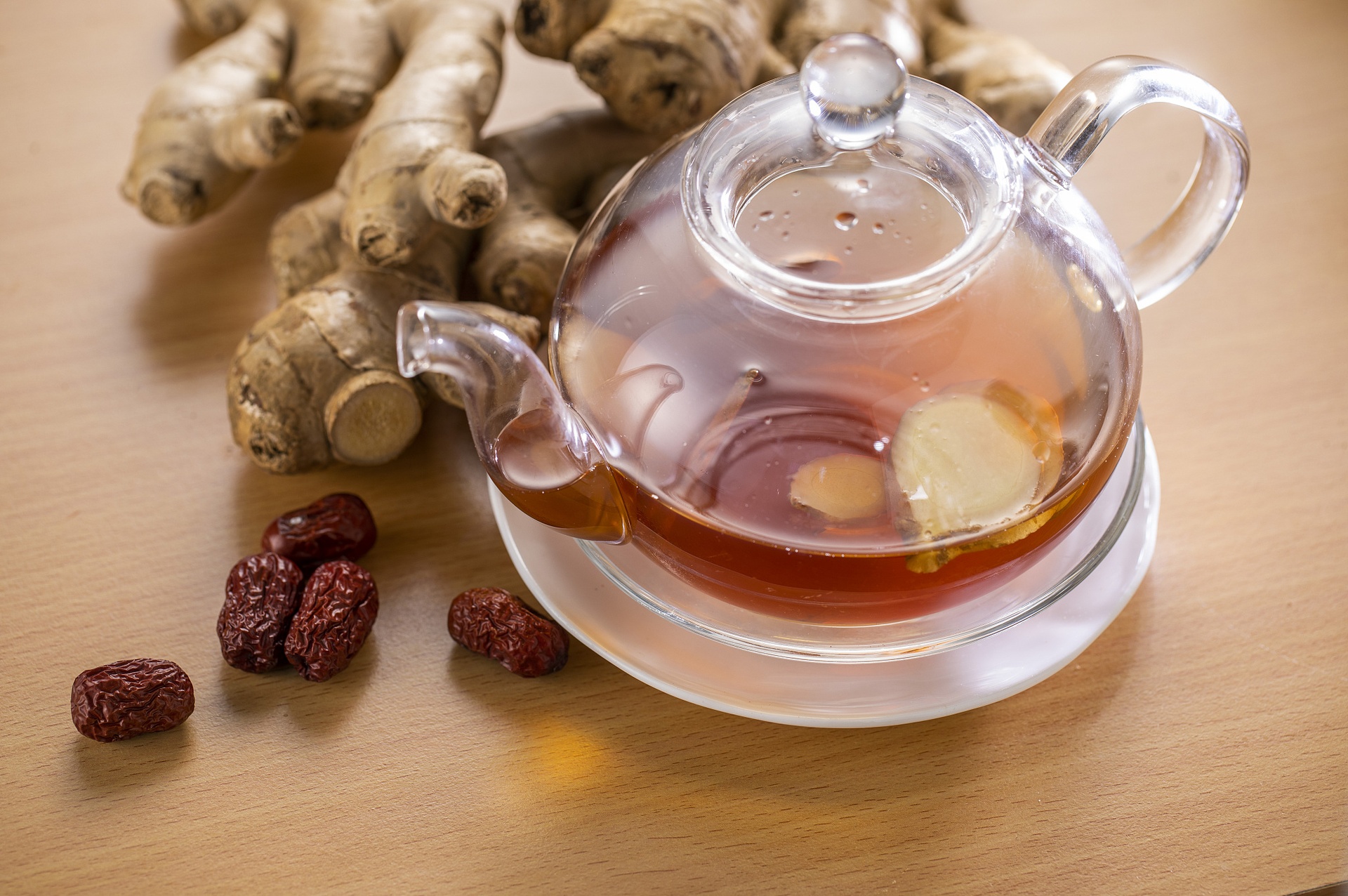 成品姜母红枣茶特写：200mL陶瓷杯盛装，汤色为清亮琥珀色，可见细微姜油星点悬浮，杯底沉淀少量枣肉纤维，无焦糊色或浑浊