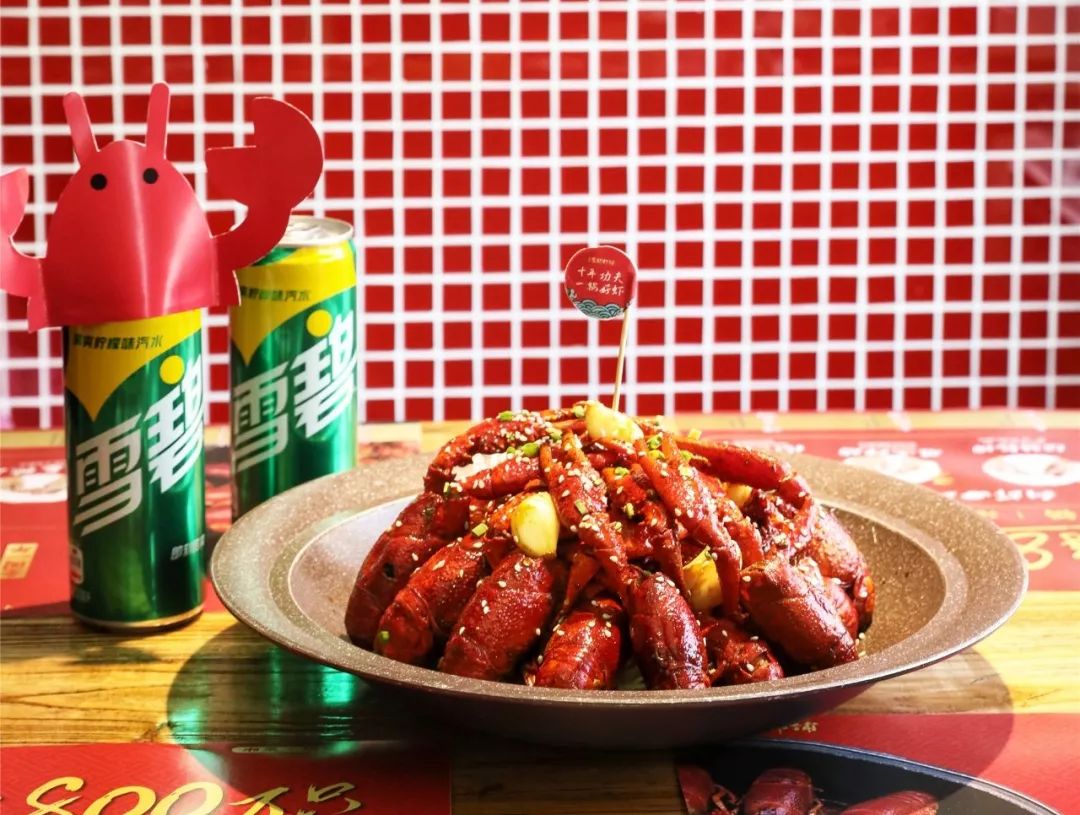 一家三口围坐在餐桌前开心地享用麻辣小龙虾,桌上摆有啤酒杯、纸巾盒和调料碟,灯光温暖,气氛温馨,展现家庭聚餐的美好画面 家庭制作麻辣小龙虾场景图
