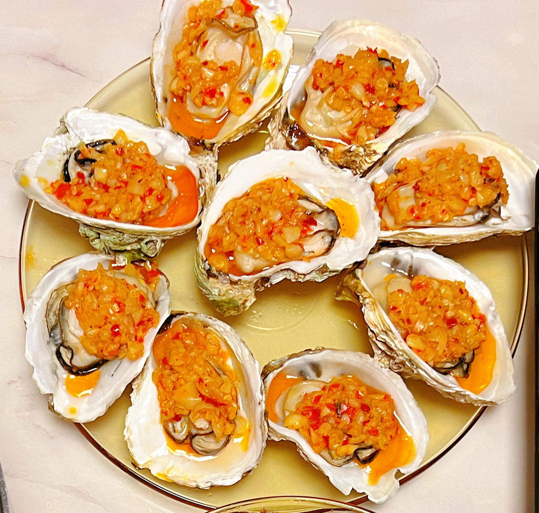 蒜蓉生蚝成品特写：金黄酥脆蒜蓉覆盖饱满乳白蚝肉，壳内汁水丰盈，表面可见细微焦糖化斑点