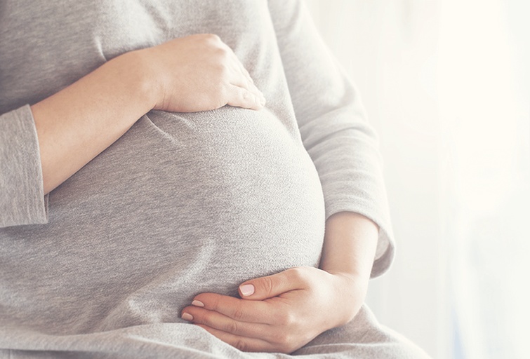 一名身穿白大褂的女医生坐在诊室内,正与一位孕妇面对面交流,桌上摆放着孕期营养手册和一份饮食记录表,墙上挂着人体营养构成图,氛围专业而亲切 医生与孕妇面对面咨询饮食问题