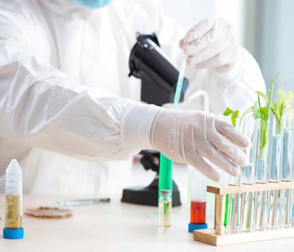 一位身穿白色实验服的科研人员正在实验室中使用高倍光学显微镜观察培养皿中的植物组织样本,旁边摆放着标注‘Herbicide Resistance Test’(除草剂抗性测试)的试管和记录本,展现除草剂作用机理研究的科学过程 实验室科研人员在显微镜前研究植物细胞对除草剂的反应