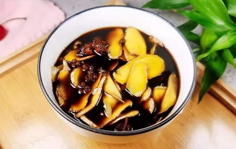 厨师正在将新鲜子姜切片加入沸腾的冬阴功汤锅中