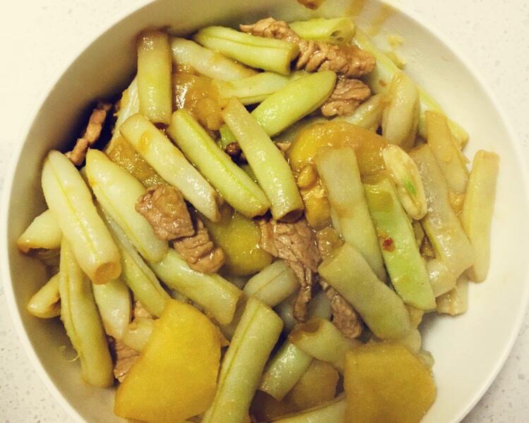 俯拍高清美食摄影:青白相间的茭白片与红椒丝、黑木耳在铁锅中翻炒,油亮润泽,边缘微焦卷曲,保留完整脆感;背景虚化处可见焯水用不锈钢漏勺与竹笋干作参照,强调‘代笋’主题 茭白快炒成菜特写