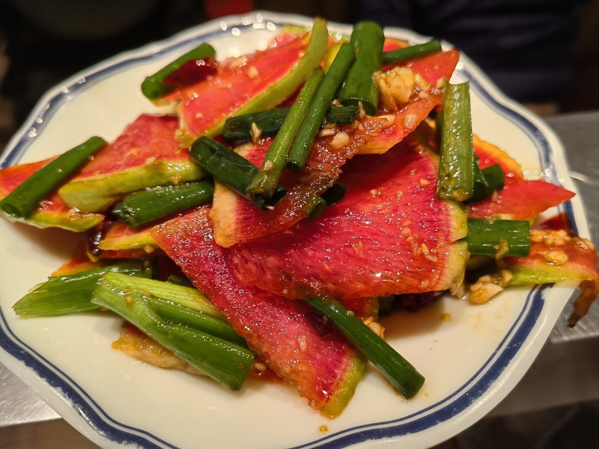 美食摄影:红心萝卜凉拌成品,突出紫红色泽、脆爽质地与传统中式调味组合,体现性平食材的日常适配性 红心萝卜凉拌特写:紫红色萝卜丝铺底,撒白芝麻与香菜碎,淋琥珀色香醋汁,盛于青瓷小碗中