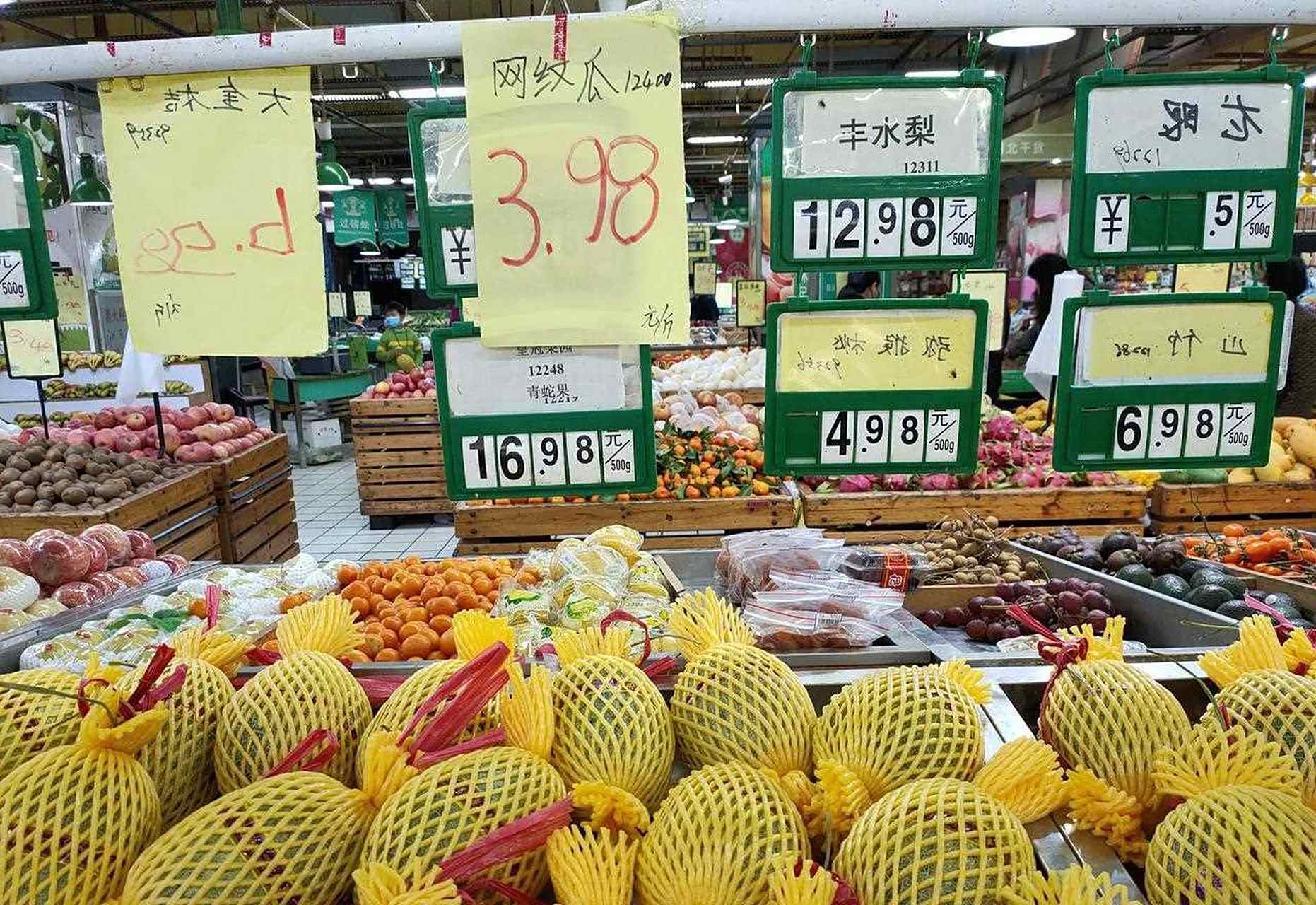 一家三口在超市水果区挑选香蕉的场景,母亲手持两串香蕉进行对比,孩子指着其中一串较自然的香蕉,父亲查看标签信息,背景清晰显示‘新鲜直达’‘自然熟’等宣传标语 家庭选购香蕉场景