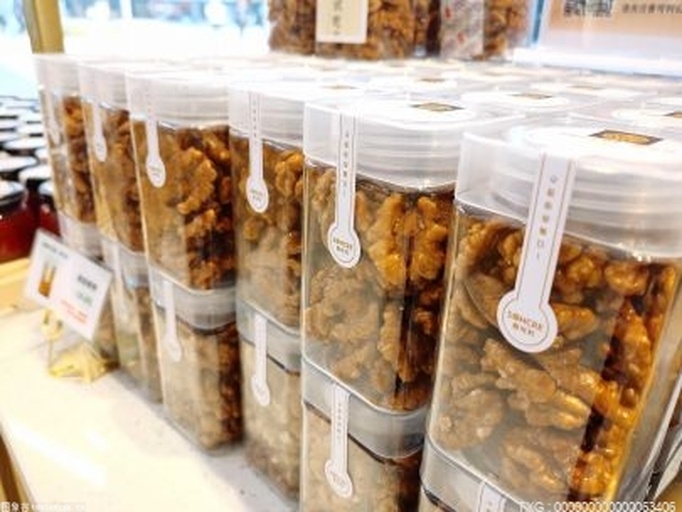 一位女性消费者在超市货架前仔细查看核桃仁包装标签,手指指向配料表,神情专注,背景为整齐排列的坚果类商品,突出理性选购的主题 消费者选购核桃仁的特写镜头