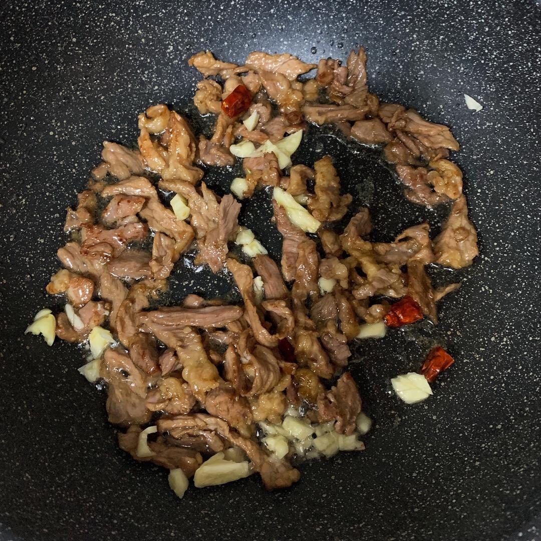 专业爆炒过程特写:展现高温快炒状态、牛肉与蒜苗形态分离度及锅气视觉效果 厨师手持中式炒锅正在颠勺,锅内牛肉片油亮分明、蒜苗翠绿挺括,火焰升腾约15cm高,背景虚化突显锅气十足的动态瞬间