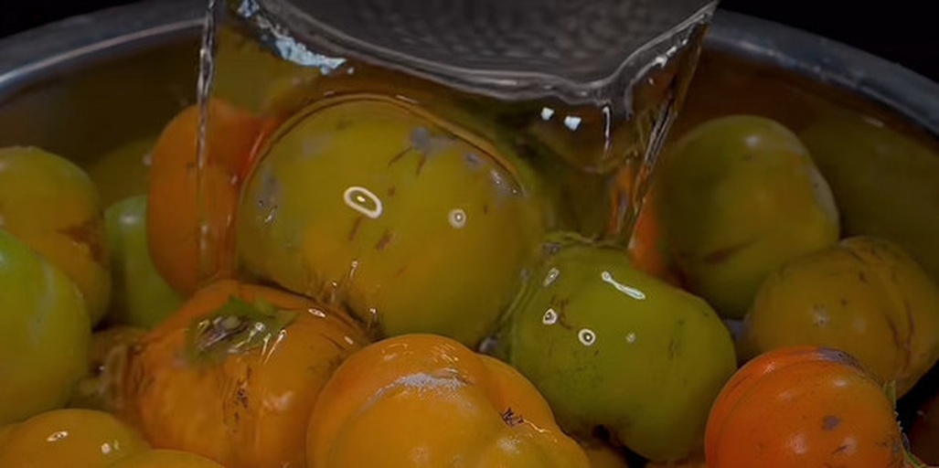 工人在光线充足的分拣车间对软柿子进行人工分级,按大小、色泽、是否有损伤分类,使用泡沫网套包裹后装入瓦楞纸箱,箱体标注‘轻拿轻放’标识,地面清洁干燥 柿子采后分级与包装现场