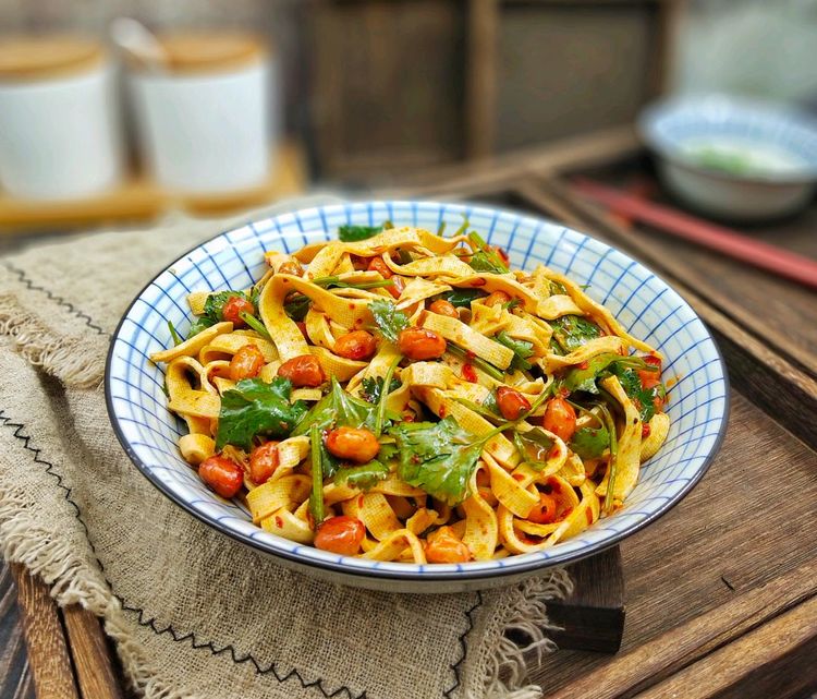 餐桌上摆放三道以香菜为主料的冬季菜肴:香菜羊肉汤、凉拌香菜豆腐丝、香菜猪肉饺子,热气氤氲,体现冬季食用场景 香菜冬季菜肴拼盘