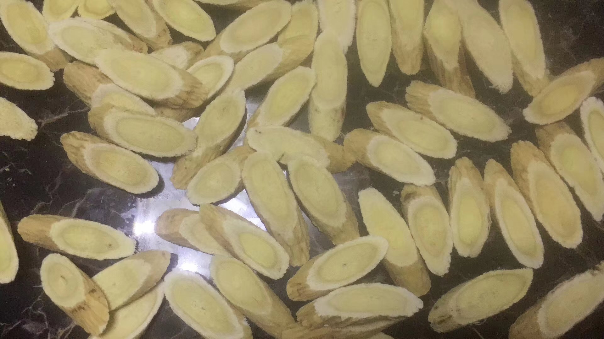 高清微距摄影:左侧为切片内蒙古武川黄芪(断面金黄、菊花心明显、纤维少)、中间为山西浑源党参(狮子盘头、横纹紧密、断面黄白相间)、右侧为饱满有机东北寒地黄豆(椭圆形、种皮光滑呈淡黄色、脐部浅褐,无虫蛀无霉变,置于白色陶瓷盘中 黄芪党参与有机黄豆原料特写