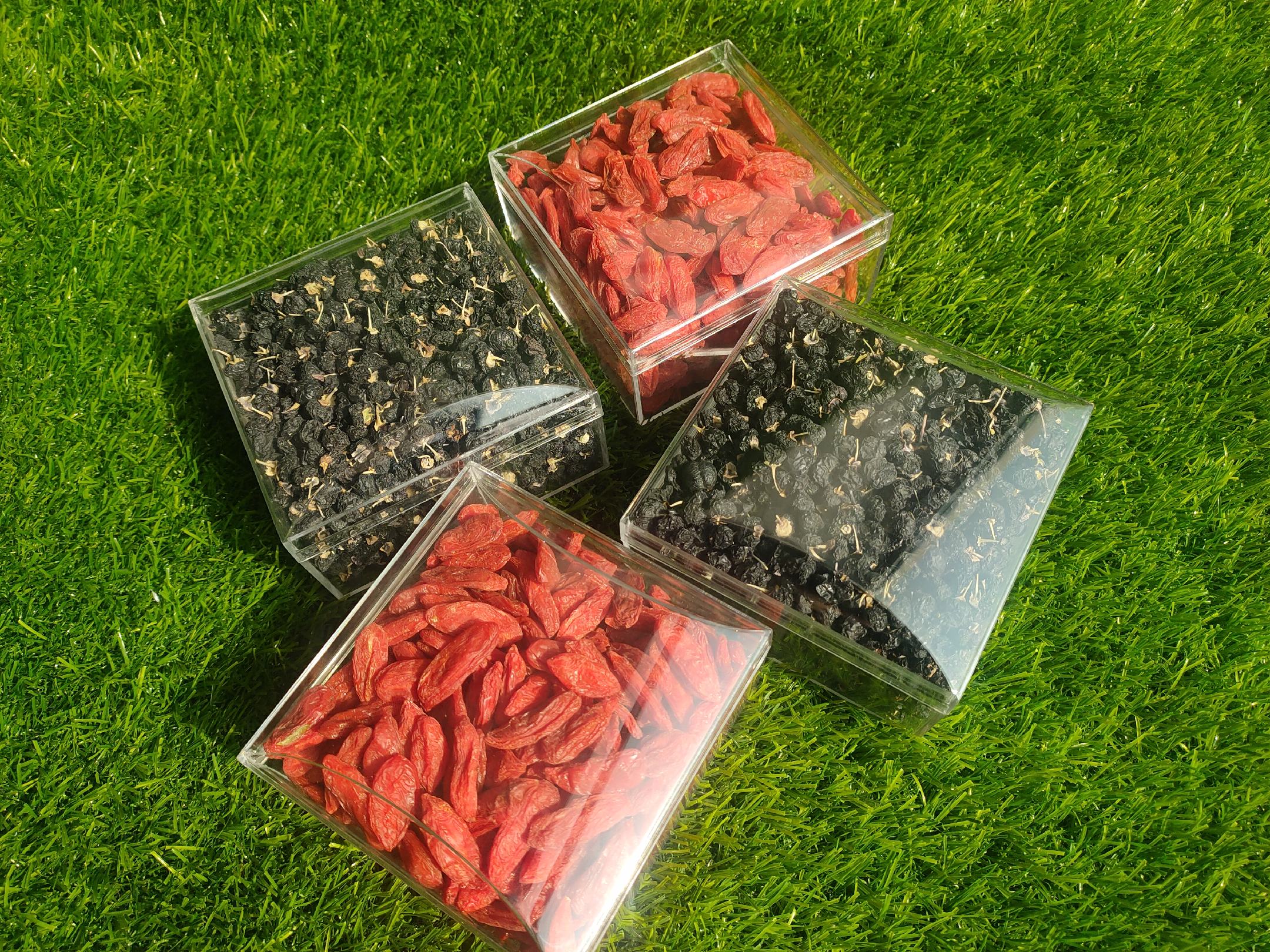 三款不同品牌的枸杞包装盒并列展示,一款标有‘有机枸杞’和‘无添加’字样,另一款标注‘食用碱处理’小字说明,第三款无任何标识信息,背景为超市货架环境 市售枸杞包装对比