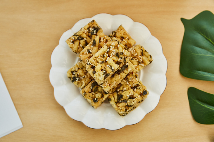 常家芝麻酥糖成品整齐摆放在盘中,色泽金黄,诱人可口 芝麻酥糖成品展示