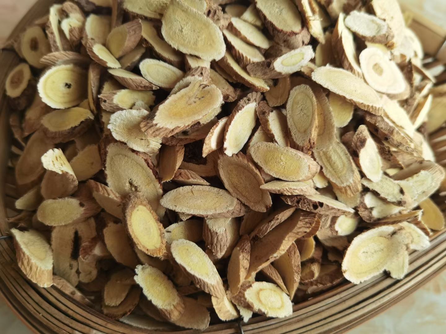 图片说明:左侧为切片的黄芪,右侧为切片的黄芩,展示两种中药材的外观特征与颜色差异 黄芪与黄芩药材对比图