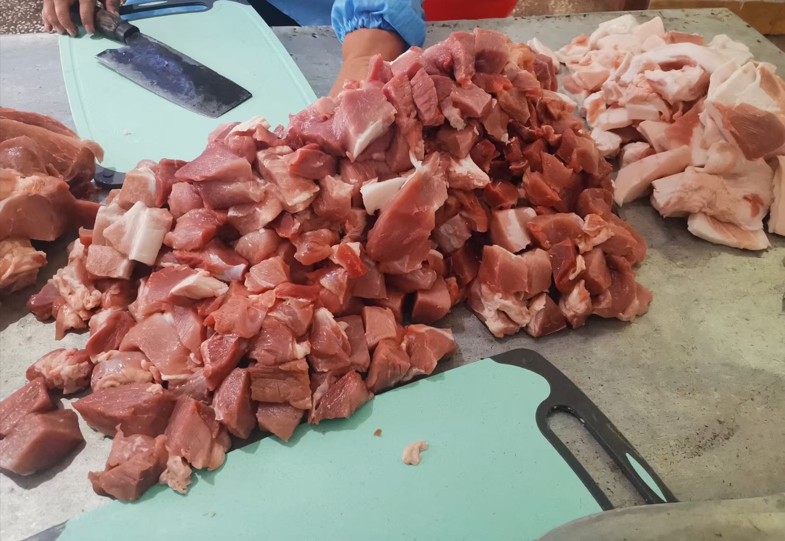 高清俯拍:翠绿蒜苗丁、粉红猪肉末、深褐泡发香菇丁均匀混合,表面泛自然油光,无明显水渍,撒少许白胡椒粉,木质砧板背景 蒜苗猪肉香菇三色馅料特写