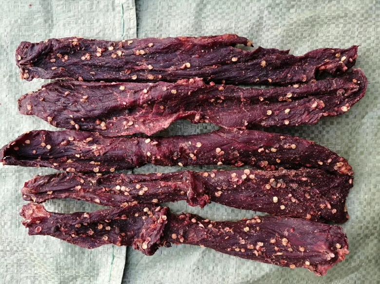 牛肉腌制过程实景图:清晰展示白胡椒粉分布状态、芡汁包裹厚度及食材新鲜度,强调‘现磨’与‘轻拌’操作细节 牛肉薄片与白胡椒腌料混合过程特写:不锈钢盆中铺开粉红色牛肉片,表面均匀裹覆半透明芡汁,撒有细密灰白色胡椒粉颗粒,旁边放置研磨中的白胡椒粒与姜汁小碟
