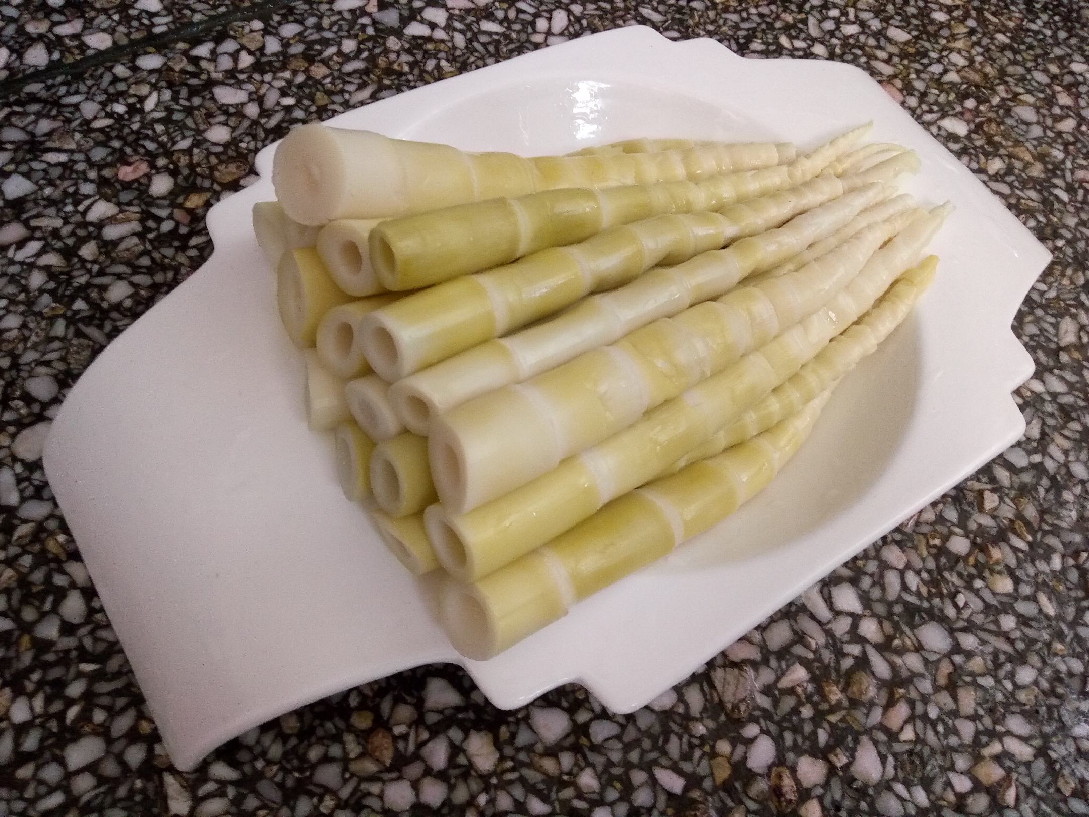 并列摆放的两盘切片竹笋,左侧苦竹笋呈淡黄色,边缘微卷,质地紧实;右侧毛竹笋洁白如玉,肉质饱满,背景为木质餐桌,旁边标注‘苦’与‘甜’标签,用于直观展示差异 对比图:左侧为苦竹笋切片(颜色偏黄、质地较硬),右侧为常见毛竹笋(洁白柔嫩)