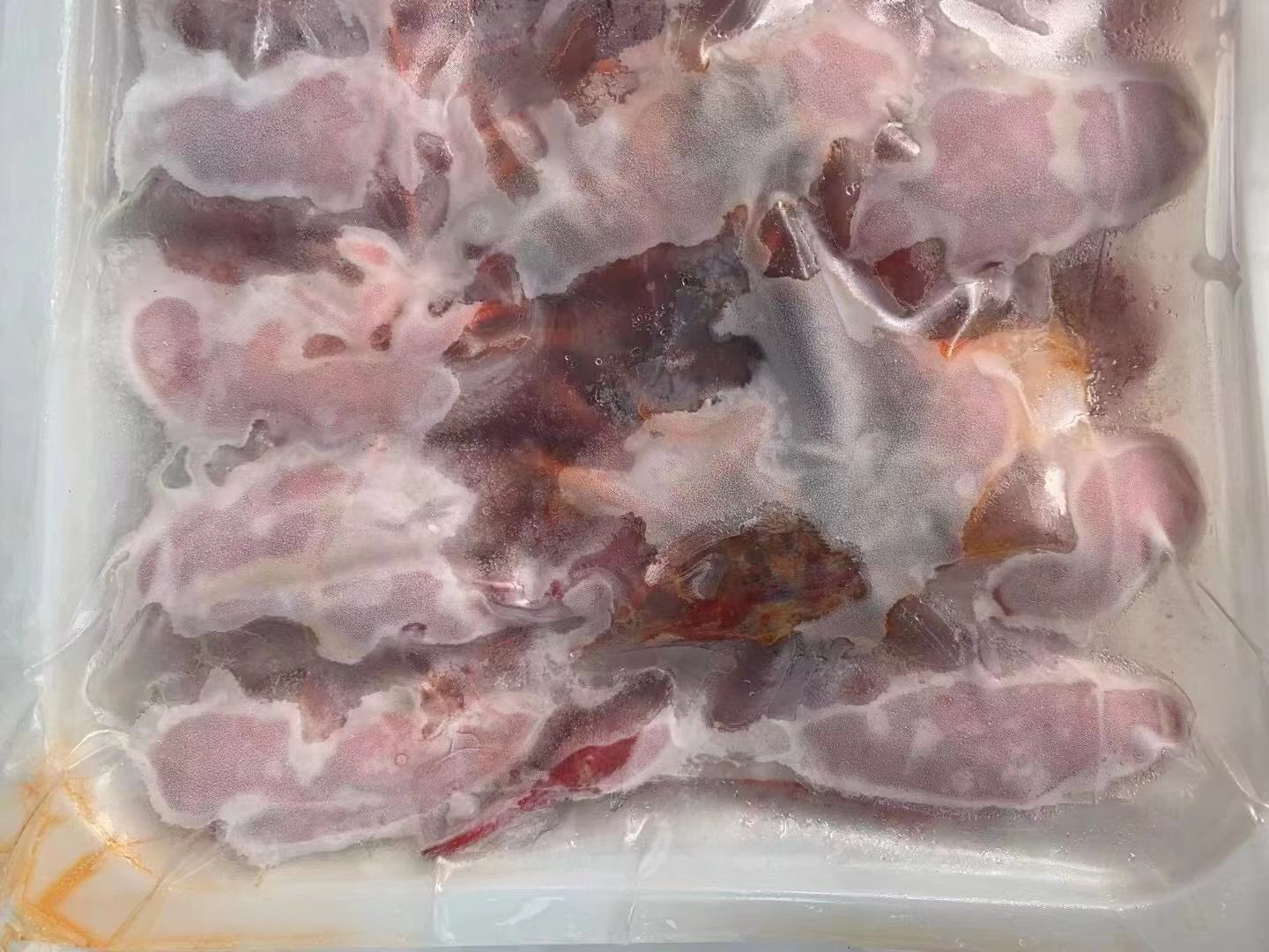 厨房场景中,一只手正在将分装好的小龙虾放入透明冷冻保鲜盒,旁边有标签笔、密封袋和冰箱冷冻室门打开的状态,展示规范的冷冻保存过程 图片描述