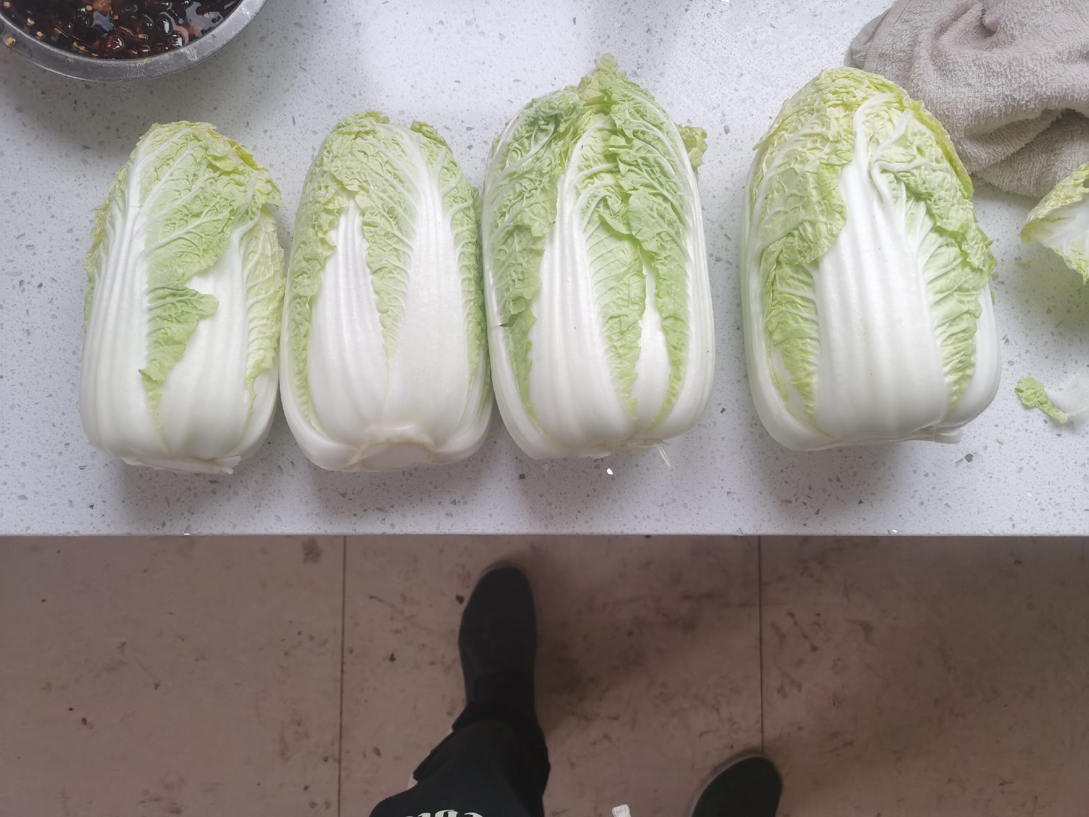 娃娃菜被切碎后放入碗中,旁边有滤网用于脱水,手正在轻轻挤压菜泥 娃娃菜切碎与脱水过程图