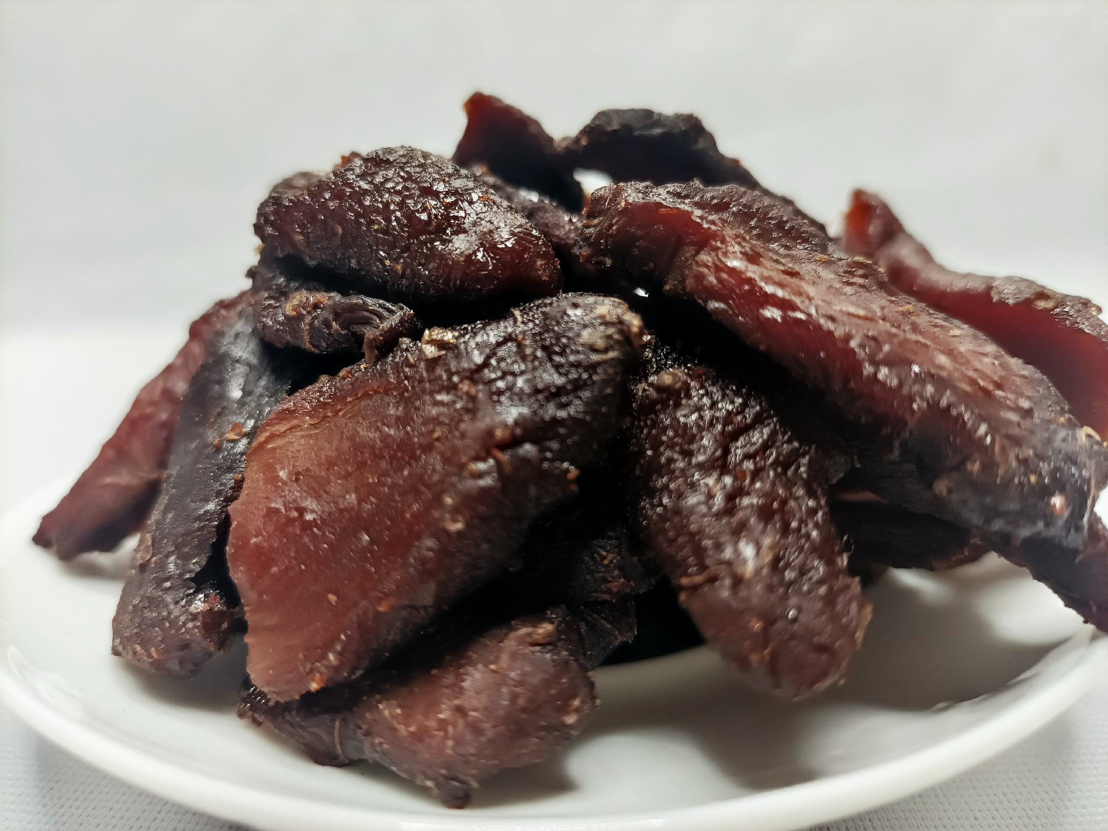 图片说明:展示一盘高质量的熟地黄成品,色泽乌黑、质地柔润 优质熟地黄成品展示图