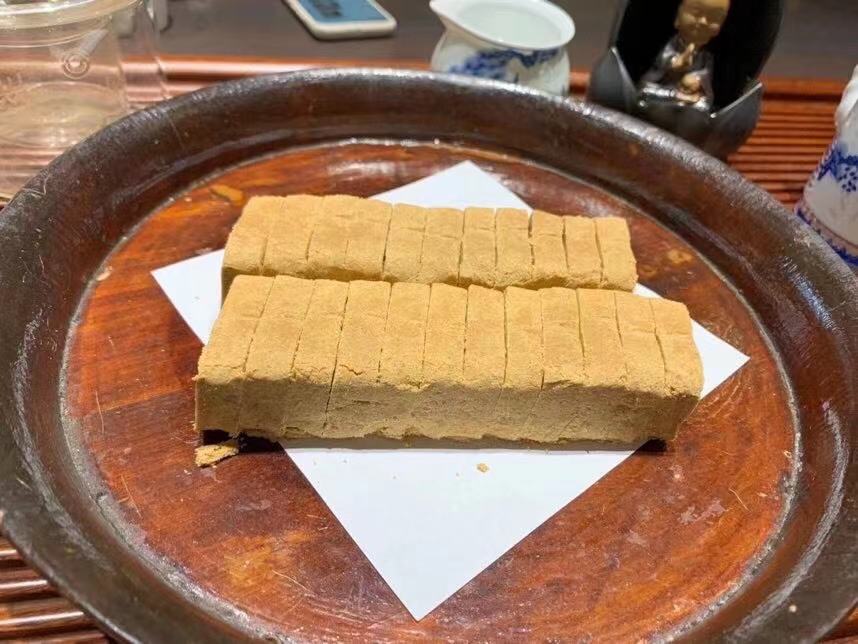 一碗盛满竹蔗、马蹄和雪梨的糖水甜品,旁边有木勺和玻璃杯,背景温暖自然 竹蔗马蹄雪梨成品图