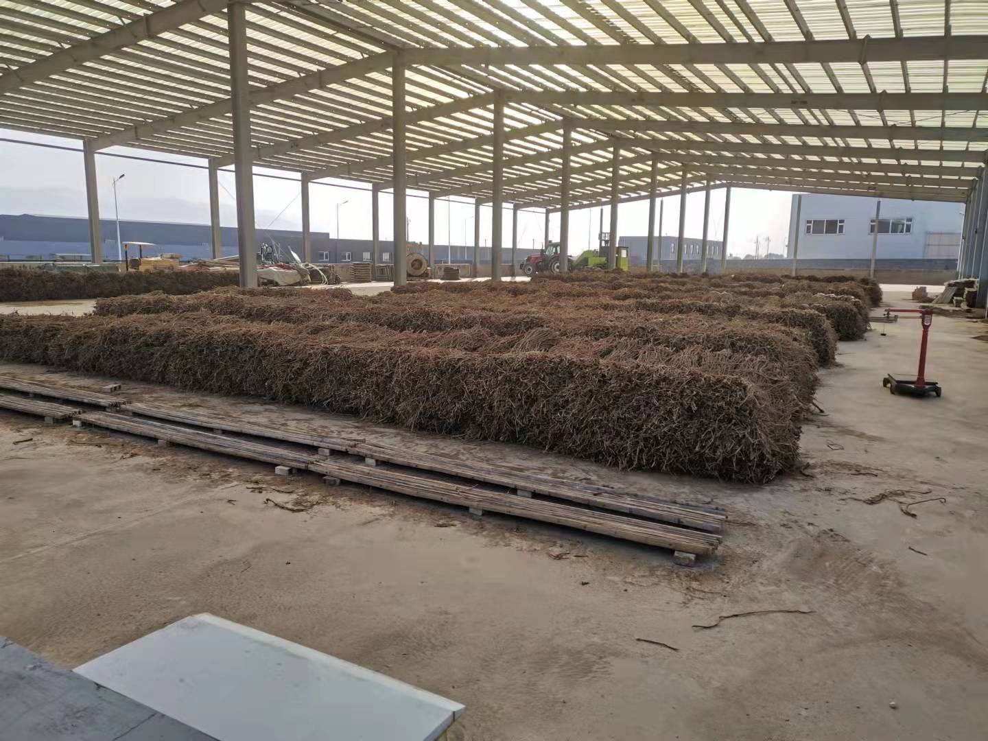 一间明亮整洁的黄芪加工厂内部,工人正在操作自动化切片机处理黄芪原材,传送带上整齐排列着刚切好的黄芪薄片,旁边有质检人员使用显微镜检查样品,墙上悬挂着‘GAP认证车间’标识牌 现代化黄芪加工车间场景