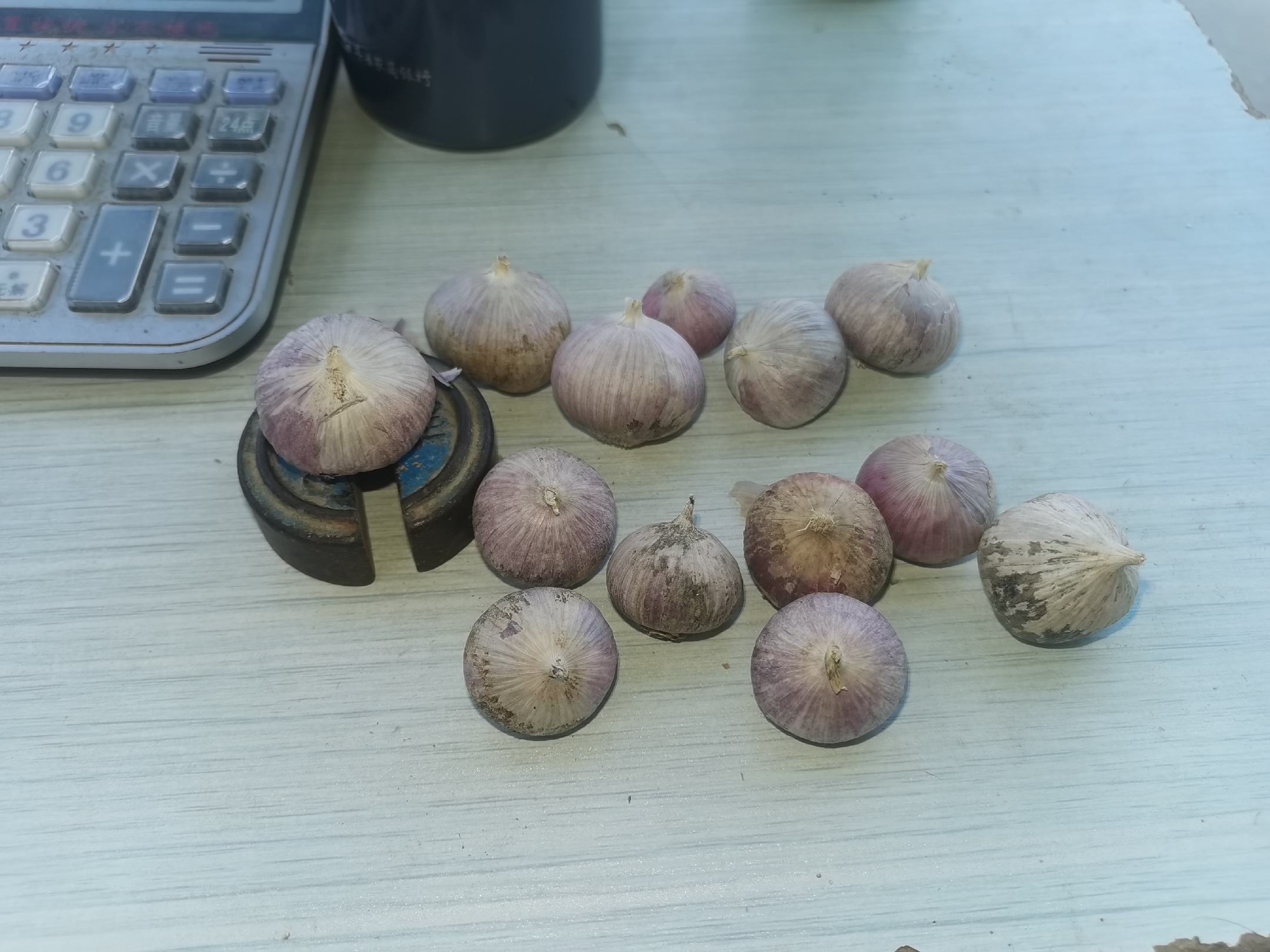 展示多个大小不一的独头蒜摆放在木桌上,背景为厨房或农田环境 独头蒜实物图