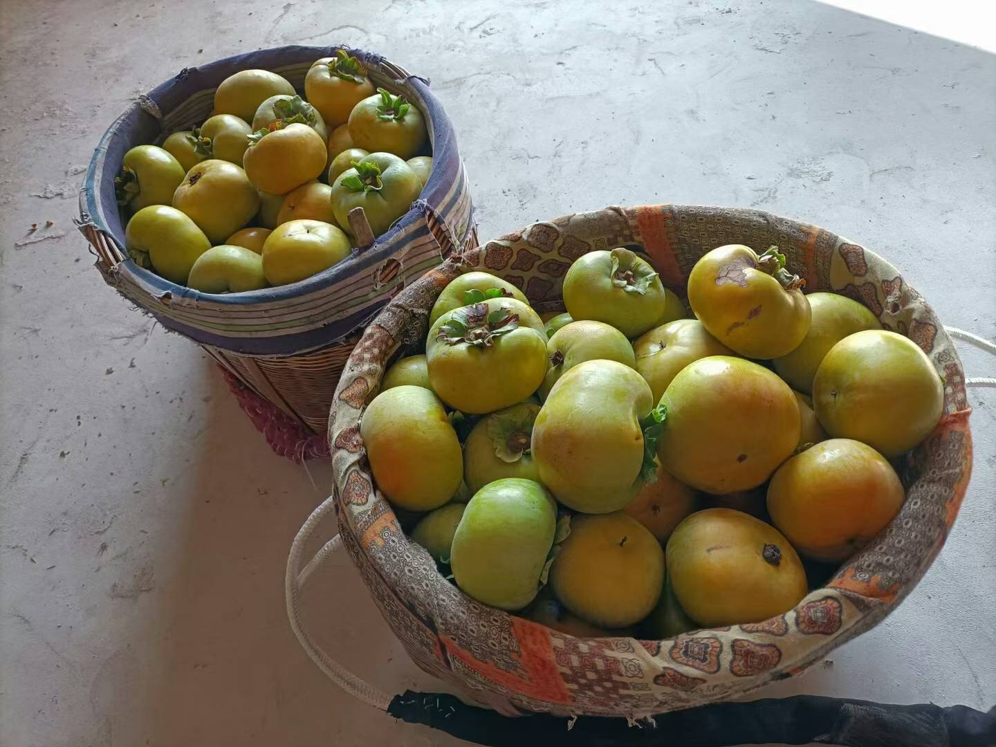 清晨的阳光下，新鲜的柿子摆放在早餐桌上