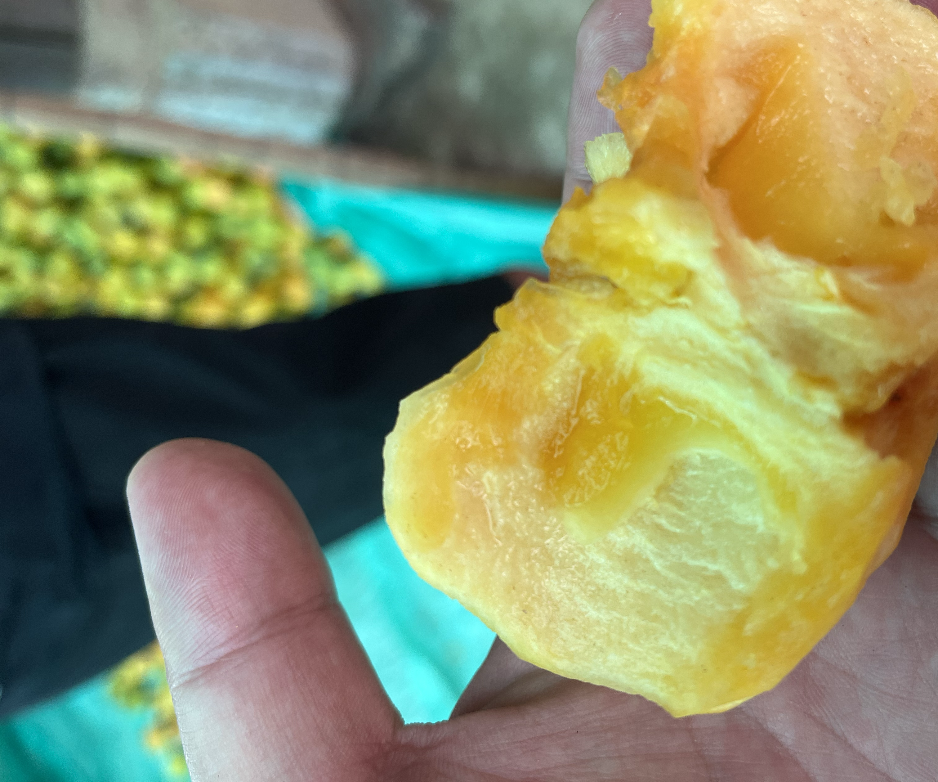 图片说明:一颗切开的冻柿子,展示其内部冰晶结构和橙红色果肉,表面覆盖一层薄霜,突显出冬季自然冷冻的特点 冻柿子特写展示其冰晶质地